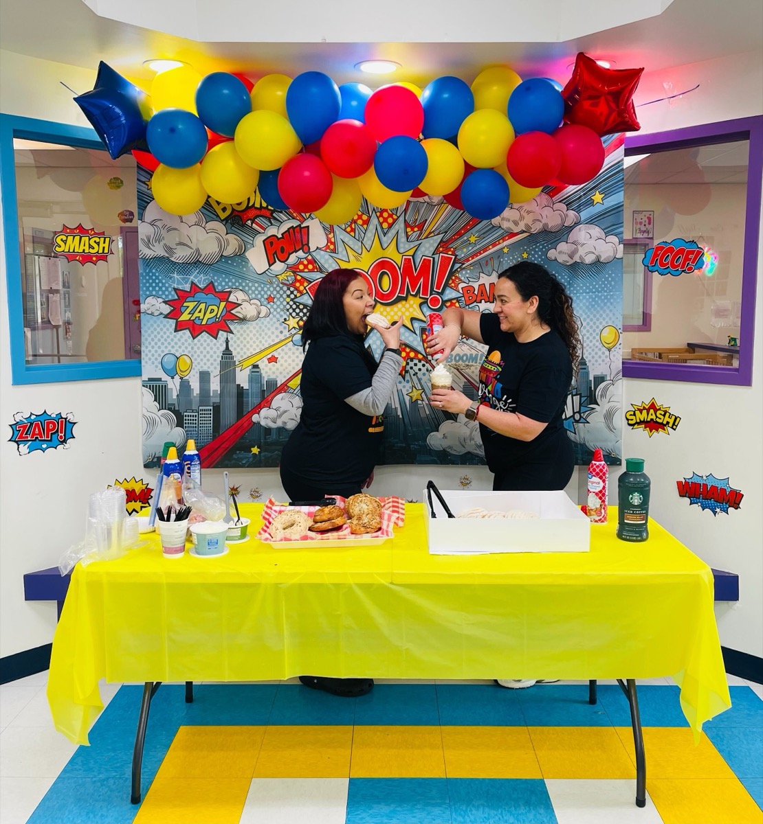 Two teachers laughing and eating donuts together